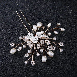 Détail d'épingle à cheveux mariée avec perles, cristaux et fleurs en fil doré