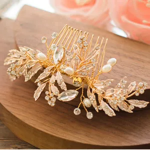 Macro detail of bridal gold leaf hair comb with rhinestones and pearls on wood