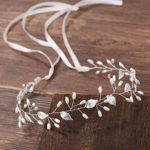 Détail de serre-tête de mariée avec feuilles argentées, perles et rubans de soie