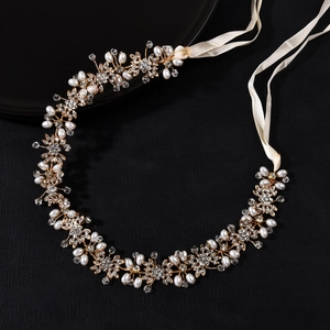 Elegante fascia da sposa dorata con strass scintillanti e perle bianche su sfondo nero