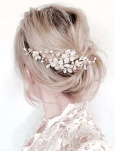Detail of bridal hair comb with white flowers, pearls, and crystals on gold wire
