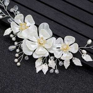 Détail de bandeau de mariée avec fleurs en soie blanche, perles et feuilles en métal argenté