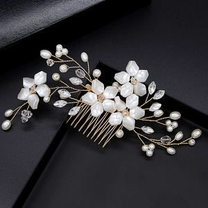 Detail of bridal hair comb with handmade pearls, crystals, and white flowers on gold wire