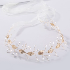 Détails des feuilles dorées et perles blanches sur le ruban du bandeau mariée
