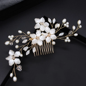 Detailed close-up of bridal hair comb with white flowers, pearls and crystals on black