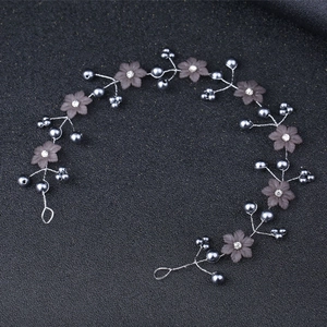 Detailed view of handmade bridal hairband with black pearls and frosted flowers decoration
