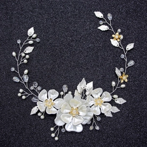 Bijou de tête mariée avec fleurs en satin blanc, perles et feuilles de cristal sur fond noir