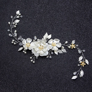 Détail d'une vigne à cheveux de mariée avec fleurs blanches, feuilles et perles
