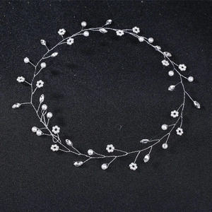 Detailed close-up of handmade bridal headband with white pearls and crystals on black background