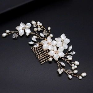 Macro shot of bridal hair comb with white flowers, pearls and crystals on black background