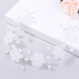 Détail de fleurs blanches mates et perles sur une vigne de cheveux de mariée