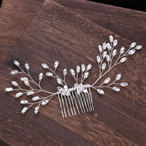 Macro detail of handmade silver bridal hair comb with marquise crystals on wood