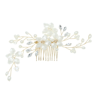 Macro detail of bridal hair comb with handmade white flowers, pearls, and crystals on gold wire