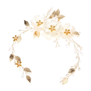 Détail de coiffe de mariée faite main avec fleurs en soie, feuilles d'or et perles