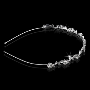 Silver bridal headband featuring floral rhinestone patterns on a sleek black reflective surface