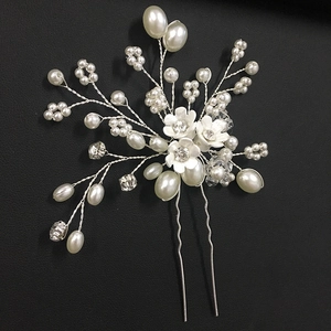 Détail de l'épingle à cheveux de mariée argentée avec perles blanches et fleurs strass