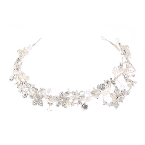 Close-up of bridal headpiece featuring white pearls, crystals, and silver floral patterns