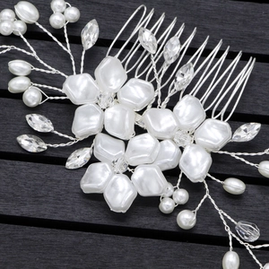 Close-up of bridal hair comb with pearls, crystals and white floral petal details