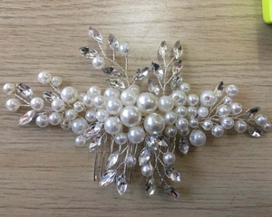 Détail du peigne de mariée avec perles et cristaux marquise sur fond en bois