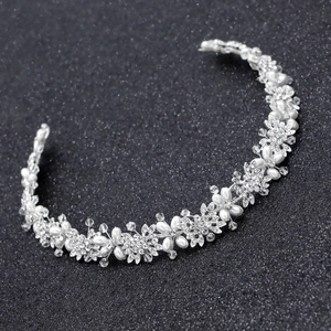 Dettaglio della fascia da sposa argentata con strass scintillanti e perle bianche