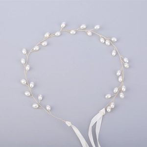Detailed macro view of delicate gold twisted wire vine bridal hairband with white pearls