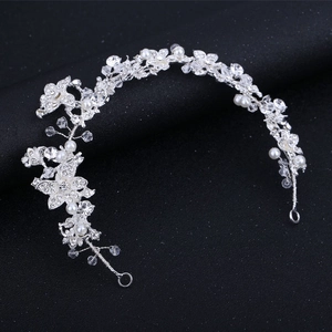 Close-up of bridal headband with silver flower alloy patterns, white pearls and clear crystals