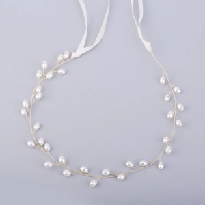 Detail of handcrafted bridal headband with white pearls and gold wire on white silk ribbons