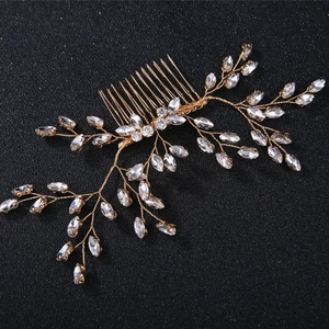 Golden bridal hair comb with crystal rhinestones and leaf branch design on black background
