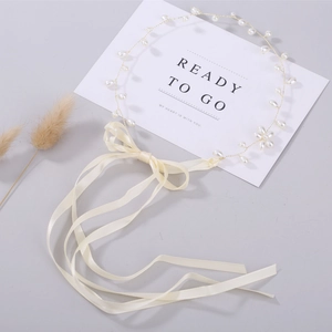 Detail of handmade gold wire pearl headband with elegant cream ribbon for wedding styling