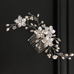 Macro shot of silver wire bridal hair comb with white pearls and crystal floral details