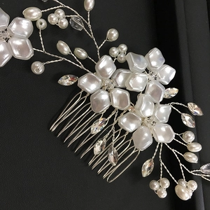 Detailed macro view of handmade bridal hair comb with pearls and clear crystals