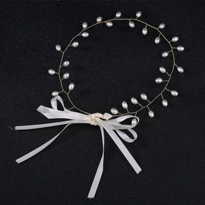 Detail of handmade gold wire hairpiece with white pearls and silk ribbon bow