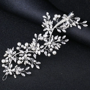Elegant bridal hair vine with sparkling rhinestones and white pearls on a black background