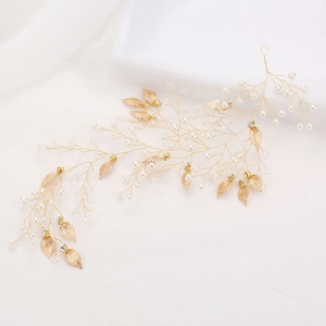 Détail d'une vigne de cheveux de mariée avec feuilles dorées, perles et cristaux