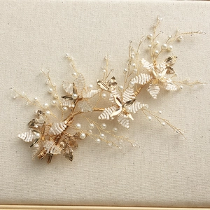 Detailed close-up of handmade bridal headpiece with white beads and golden leaves