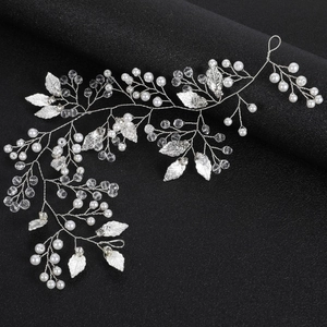 Détails d'un accessoire de cheveux mariée fait main avec perles, cristaux et feuilles