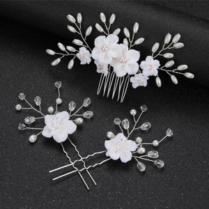 Detailed close-up of bridal white flower hair comb set with pearls and silver wire
