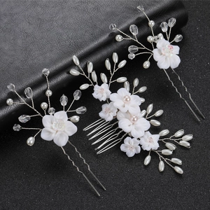Detailed macro view of handmade bridal hair comb set with white flowers and pearls