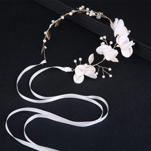 Serre-tête de mariée élégant avec fleurs blanches et perles sur fond noir contrasté