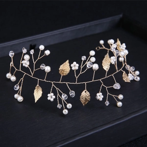 Detail of golden leaf hair vine with pearls and crystals on a black jewelry tray