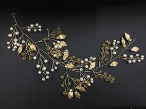 Détail de vigne à cheveux feuilles dorées avec perles blanches et cristaux bruns à la main