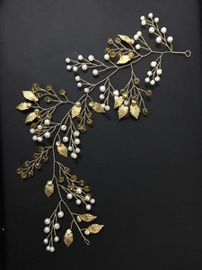 Détail d'une vigne à cheveux de mariée dorée avec perles et feuilles artisanales