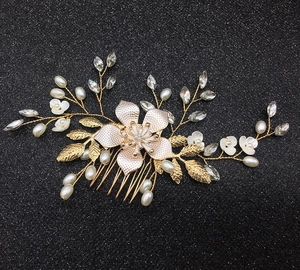 Detail shot of a handmade bridal hair comb with golden alloy flowers and white pearls