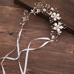 Detail der Braut-Haarranke mit goldener Drahtbasis, weißen Blumen und Perlenbesatz