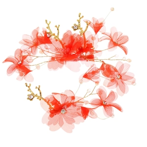Détail de pinces à cheveux en tulle rouge avec branches dorées, perles et strass
