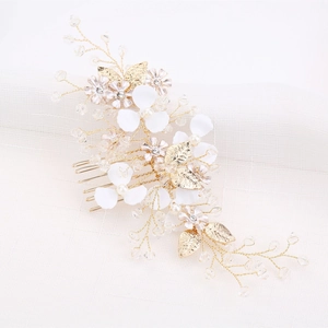 Détail du peigne de mariée avec fleurs blanches, feuilles dorées et perles de cristal