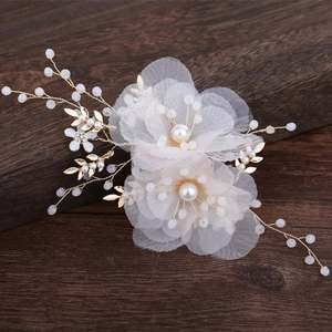 Fermaglio da sposa con fiori in rete e perle su sfondo in legno scuro
