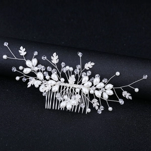 Elegant bridal hair comb with pearls, crystals, and silver leaves on black background