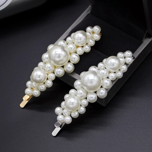 Detalle de horquillas de perlas con bases de aleación en oro y plata en joyero chic