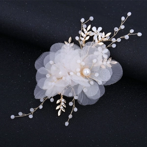 Dettaglio del pettine da sposa con petali in tulle, foglie dorate e accenti di perle